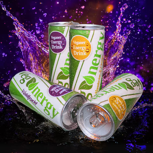 Vier Vegenergy Dosen aus der Starterbox in den Sorten Mandarine & Orange und Waldfrucht, umgeben von lila spritzendem Wasser, zwei Dosen mit Papierstrohhalm.